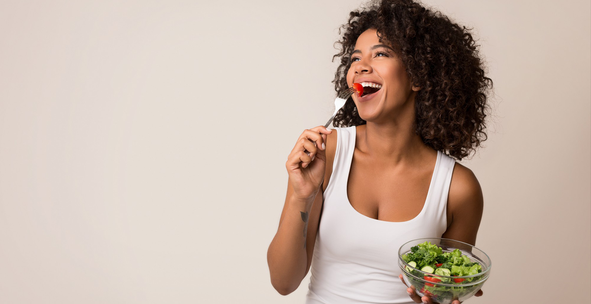 mulher feliz comendo salada